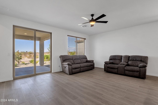 living room featuring light hardwood / wood-style flooring and ceiling fan