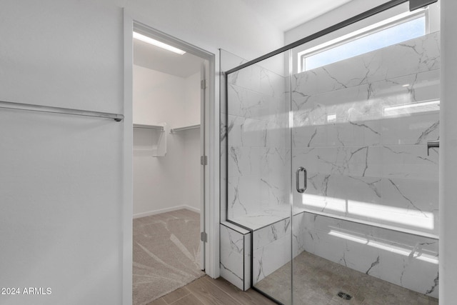 bathroom with a shower with door and wood-type flooring