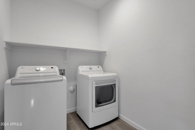 clothes washing area featuring hardwood / wood-style floors and washer and clothes dryer