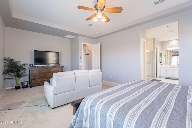 bedroom with connected bathroom, light carpet, and ceiling fan