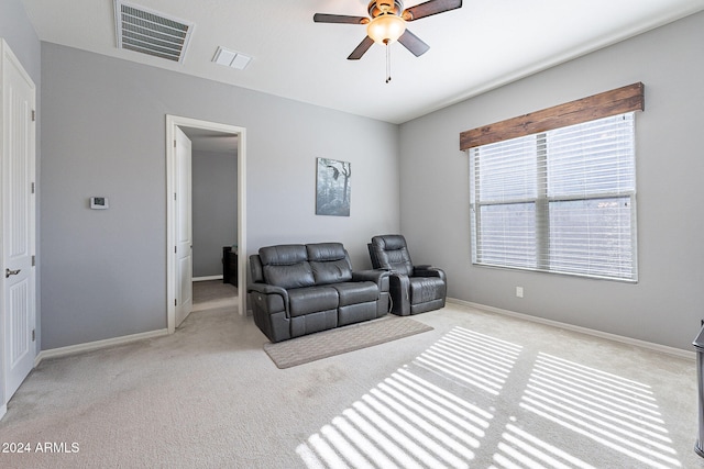 living area featuring ceiling fan and light colored carpet