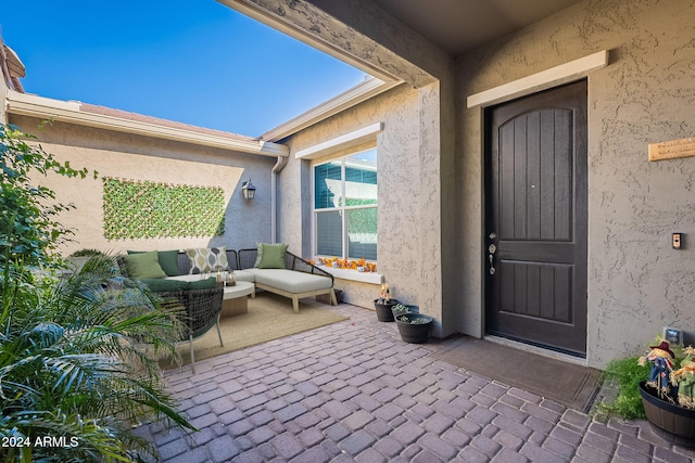 property entrance with an outdoor living space and a patio