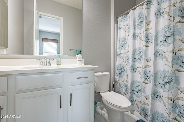 bathroom featuring vanity, curtained shower, and toilet