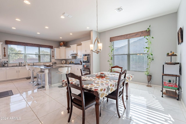 dining room with a notable chandelier and light tile patterned flooring