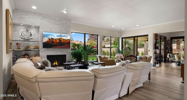 4450 E Camelback Rd Unit 4, Phoenix, AZ 85018 - living room with crown molding, recessed lighting, a stone fireplace, and wood finished floors
