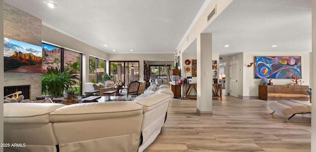 4450 E Camelback Rd Unit 4, Phoenix, AZ 85018 - living room with a stone fireplace, visible vents, baseboards, light wood-style floors, and recessed lighting