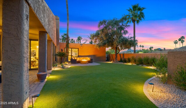 4450 E Camelback Rd Unit 4, Phoenix, AZ 85018 - yard at dusk featuring an outdoor living space, a fenced backyard, and a patio area