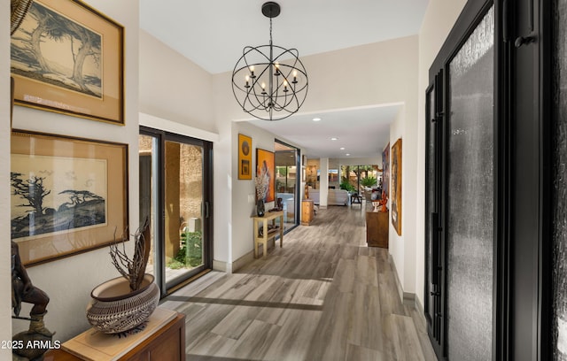 4450 E Camelback Rd Unit 4, Phoenix, AZ 85018 - corridor featuring an inviting chandelier, baseboards, and wood finished floors