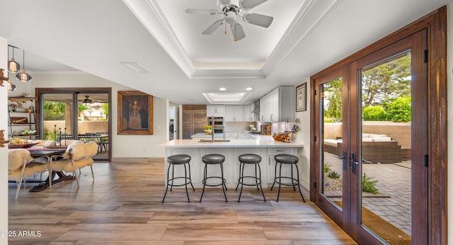 4450 E Camelback Rd Unit 4, Phoenix, AZ 85018 - kitchen with ornamental molding, a peninsula, light countertops, french doors, and a ceiling fan