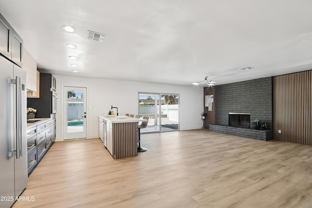 1653 E Palmcroft Dr, Tempe, AZ 85282 - kitchen featuring light countertops, stainless steel appliances, a sink, open floor plan, and light wood-style floors
