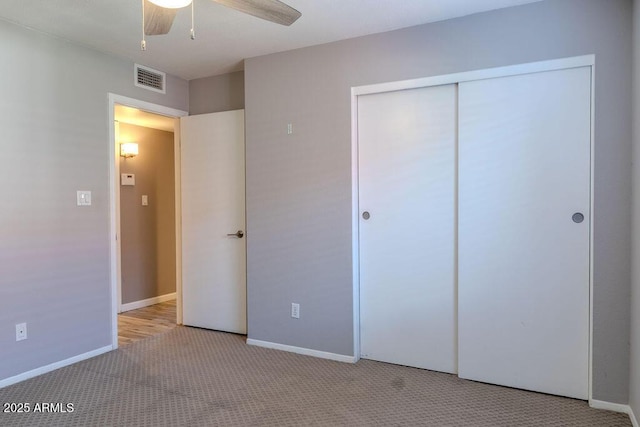 unfurnished bedroom featuring ceiling fan, light colored carpet, and a closet