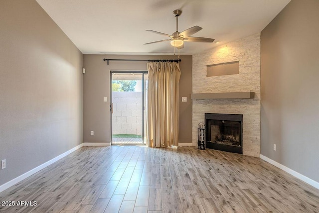 unfurnished living room featuring ceiling fan, a fireplace, and light wood-type flooring