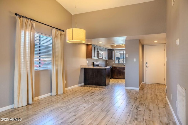 kitchen featuring sink, dark brown cabinets, stainless steel appliances, kitchen peninsula, and light wood-type flooring