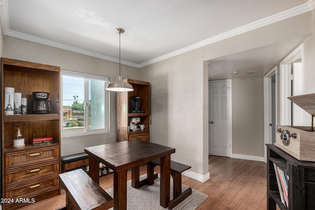 dining space with hardwood / wood-style floors and ornamental molding