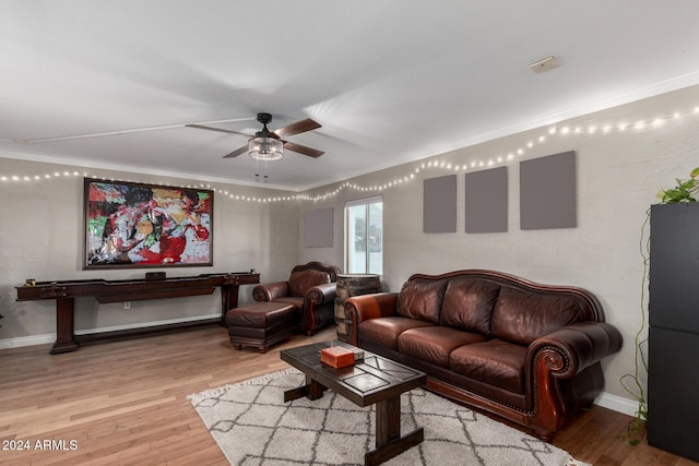 living room featuring hardwood / wood-style flooring, ceiling fan, and crown molding