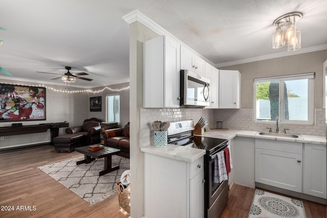 kitchen with white cabinets, sink, decorative backsplash, ceiling fan, and stainless steel appliances