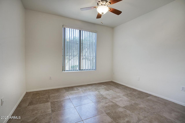 unfurnished room with a ceiling fan and baseboards