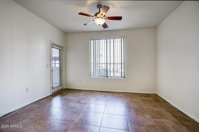 empty room with ceiling fan, baseboards, and tile patterned floors