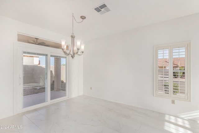 spare room with an inviting chandelier and plenty of natural light