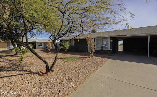 ranch-style house featuring an attached carport and concrete driveway