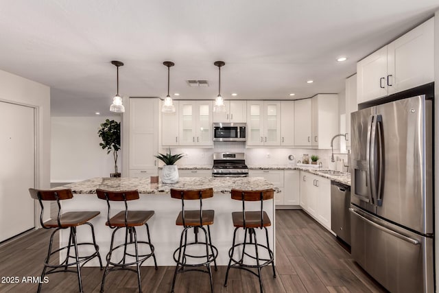 kitchen featuring visible vents, dark wood-style flooring, white cabinetry, a sink, and appliances with stainless steel finishes
