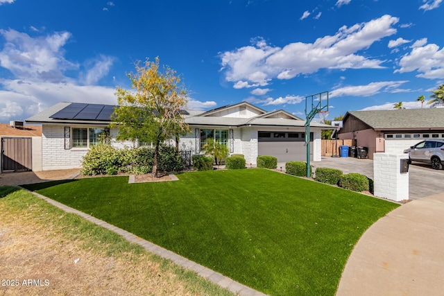 ranch-style home with a garage, fence, a front yard, driveway, and solar panels