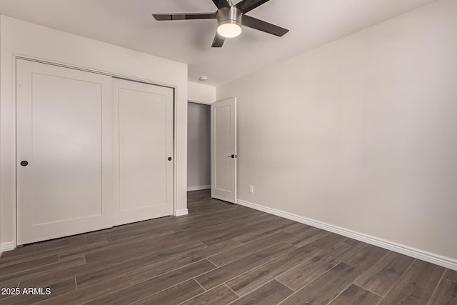 unfurnished bedroom featuring a closet, baseboards, ceiling fan, and dark wood-style floors