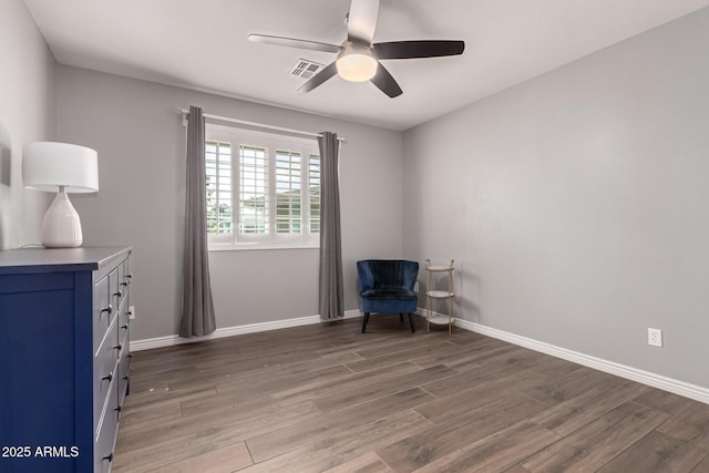 living area with a ceiling fan, baseboards, visible vents, and wood finished floors
