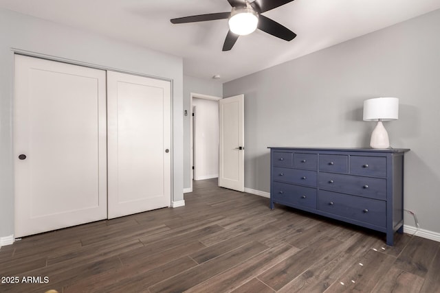 bedroom featuring a closet, baseboards, a ceiling fan, and dark wood-type flooring