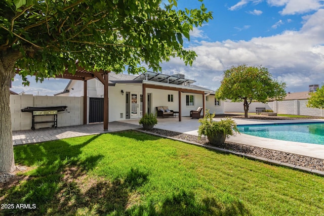 rear view of property featuring french doors, a lawn, fence, a fenced in pool, and a patio