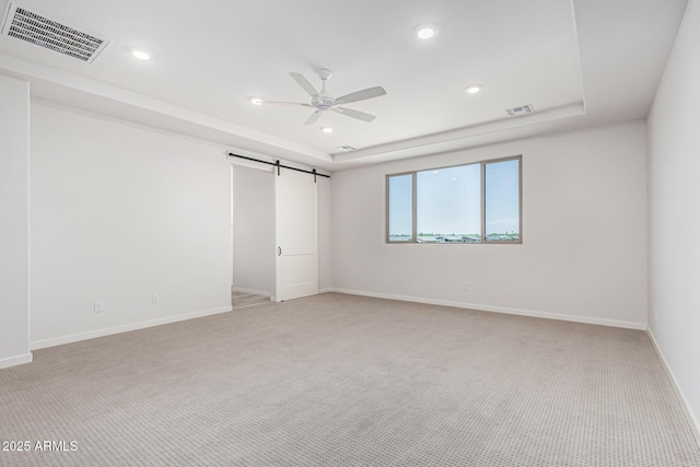 17322 W Puget Ave, Waddell, AZ 85355 - unfurnished bedroom featuring light colored carpet, a barn door, recessed lighting, a tray ceiling, and a ceiling fan