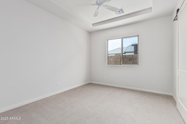 17322 W Puget Ave, Waddell, AZ 85355 - spare room featuring light carpet, a ceiling fan, and a raised ceiling
