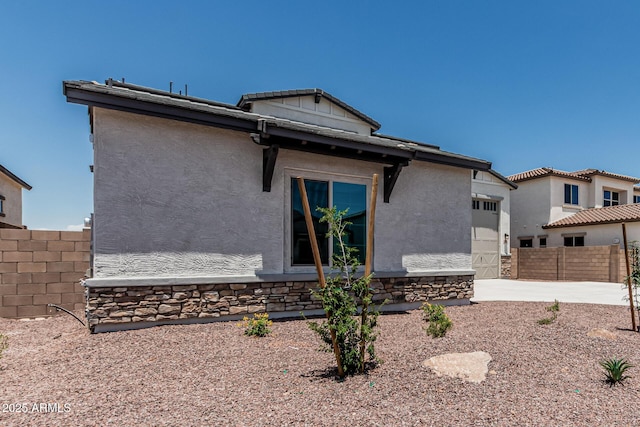 17322 W Puget Ave, Waddell, AZ 85355 - view of front facade with a garage, stucco siding, and stone siding