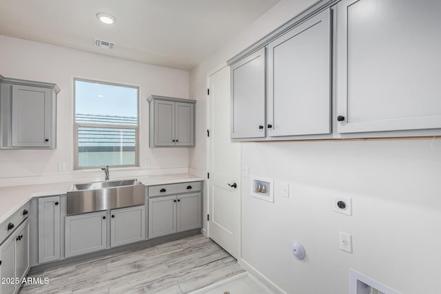 17322 W Puget Ave, Waddell, AZ 85355 - washroom with cabinet space, hookup for an electric dryer, hookup for a washing machine, gas dryer hookup, and light wood-style floors