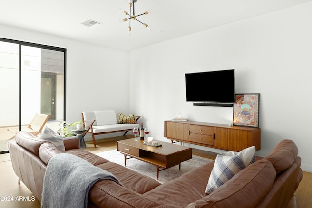 living room featuring a chandelier and light wood-type flooring