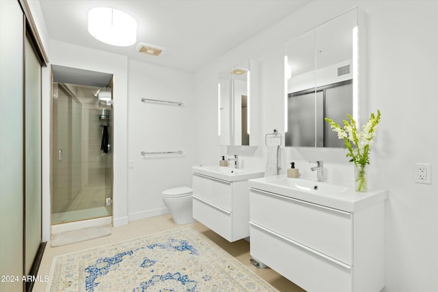 bathroom with vanity, toilet, a shower with shower door, and tile patterned flooring