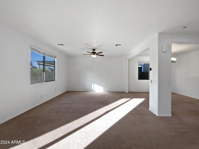 unfurnished living room featuring ceiling fan and carpet