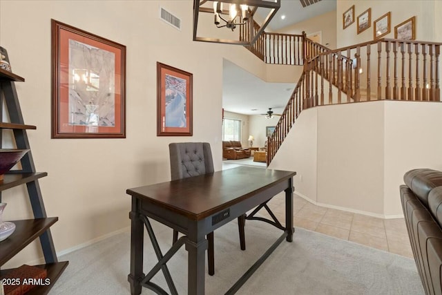 home office featuring light tile patterned flooring, an inviting chandelier, and a high ceiling