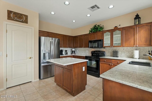 kitchen featuring sink, light tile patterned floors, tasteful backsplash, black appliances, and a kitchen island