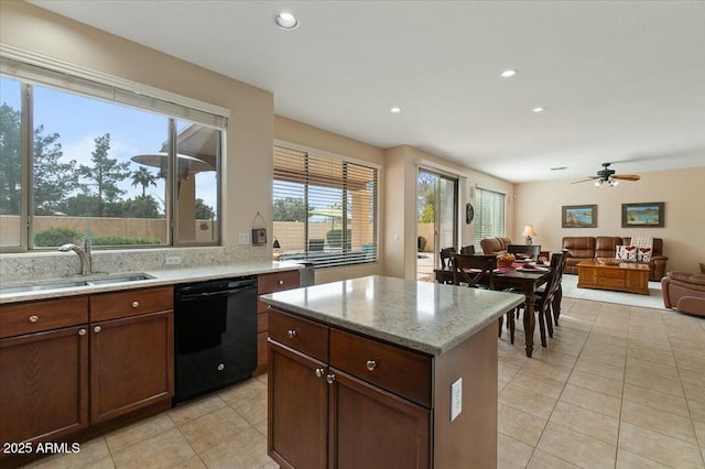 kitchen with light stone countertops, black dishwasher, sink, and light tile patterned floors