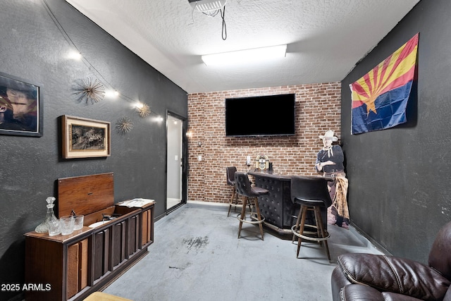 bar featuring a textured ceiling, a textured wall, and bar area