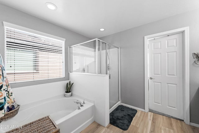 full bathroom with a stall shower, a garden tub, wood finished floors, and recessed lighting