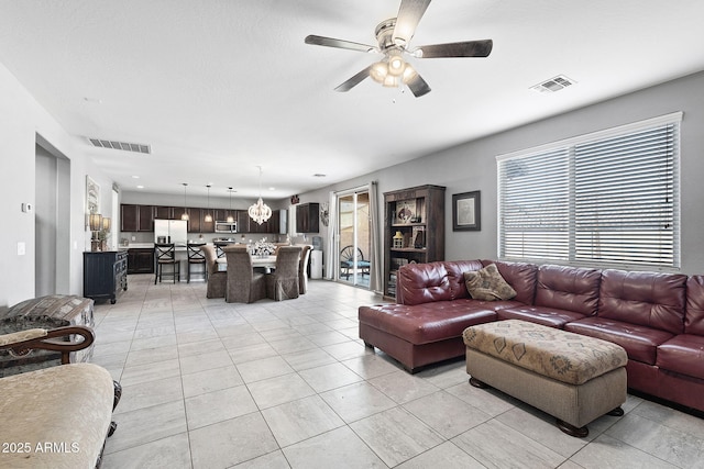 living area featuring light tile patterned floors, visible vents, and a ceiling fan