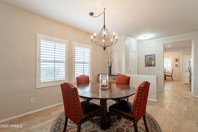 dining area with a chandelier and light wood-type flooring