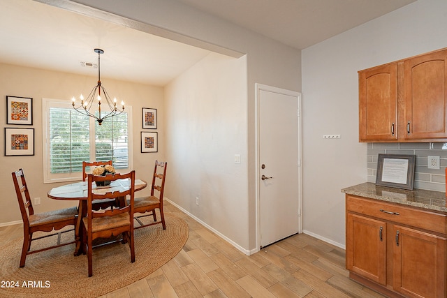 dining room with light hardwood / wood-style flooring and a notable chandelier