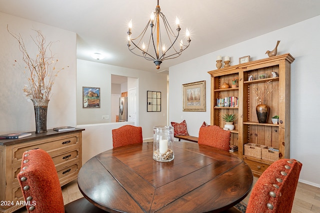 dining room featuring stacked washer and dryer, a notable chandelier, and light wood-type flooring