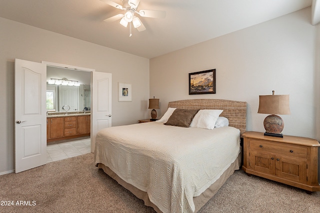 carpeted bedroom with ensuite bathroom and ceiling fan