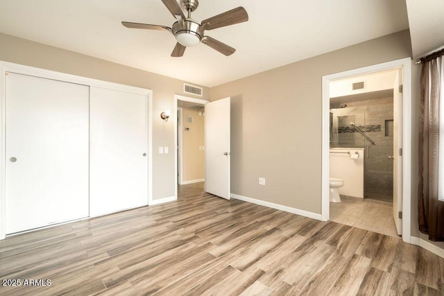 unfurnished bedroom with ensuite bath, ceiling fan, light hardwood / wood-style flooring, and a closet