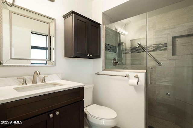 bathroom with an enclosed shower, vanity, and toilet