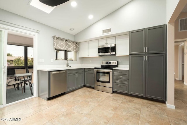 kitchen with gray cabinetry, white cabinetry, sink, high vaulted ceiling, and appliances with stainless steel finishes